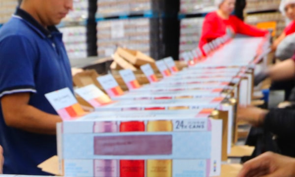 Workers packaging cans into boxes